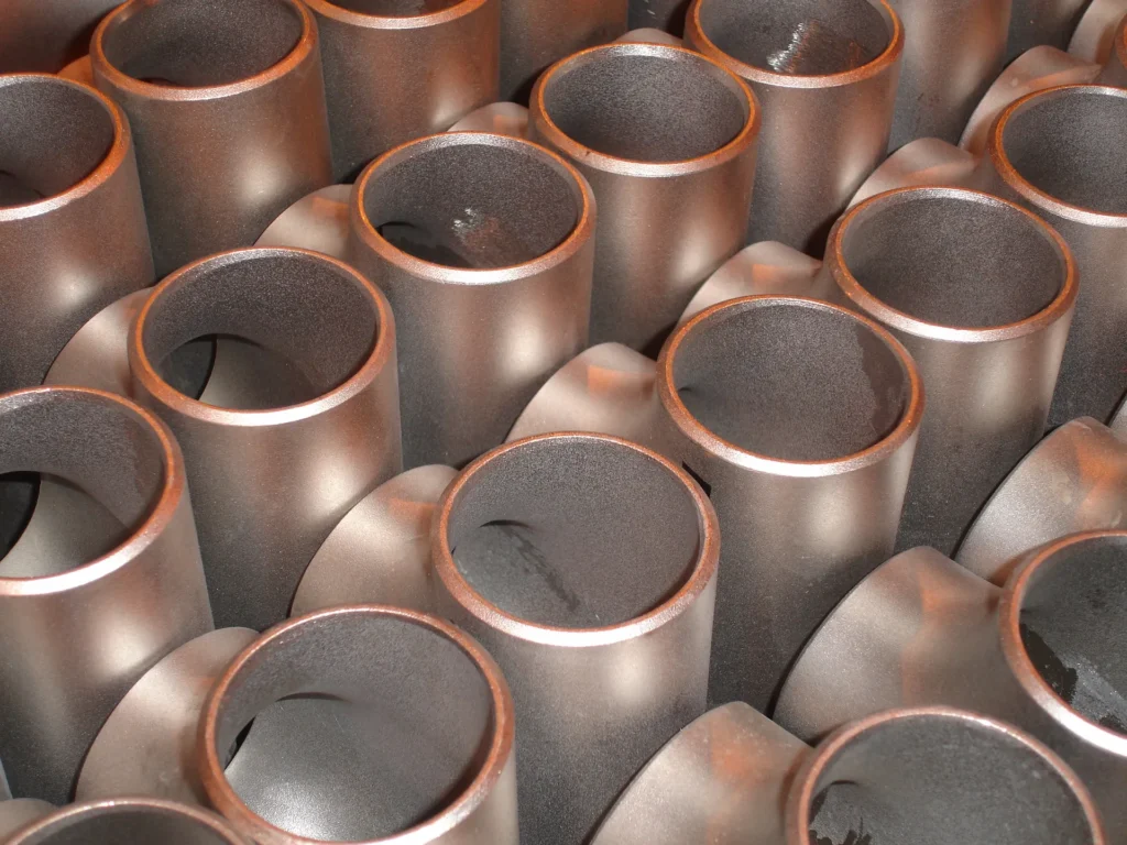 Close-up of a large pile of industrial metal pipes and fittings.